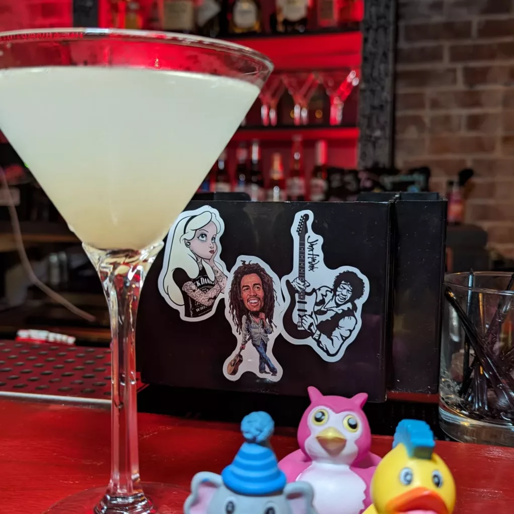 A martini in a glass with a toy on the cocktail.