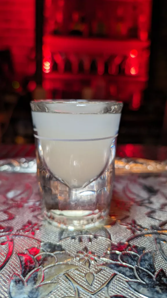 A cocktail glass of liquid on a table.