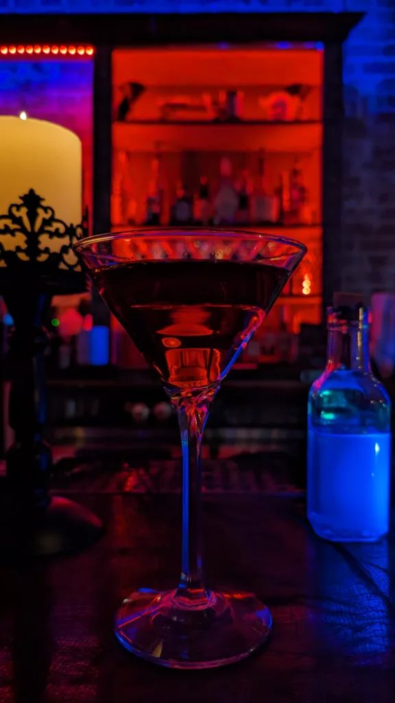 A cocktail glass on a table in a bar.