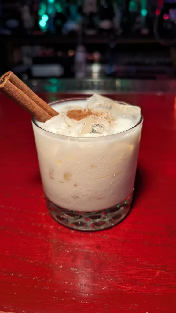 A cocktail with cinnamon and ice in a glass.